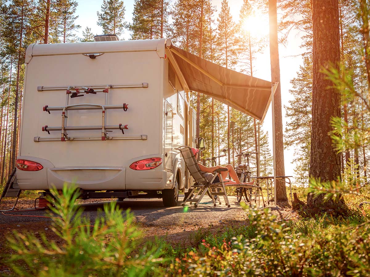 Woman relaxing at a campsite with a ceramic coated RV