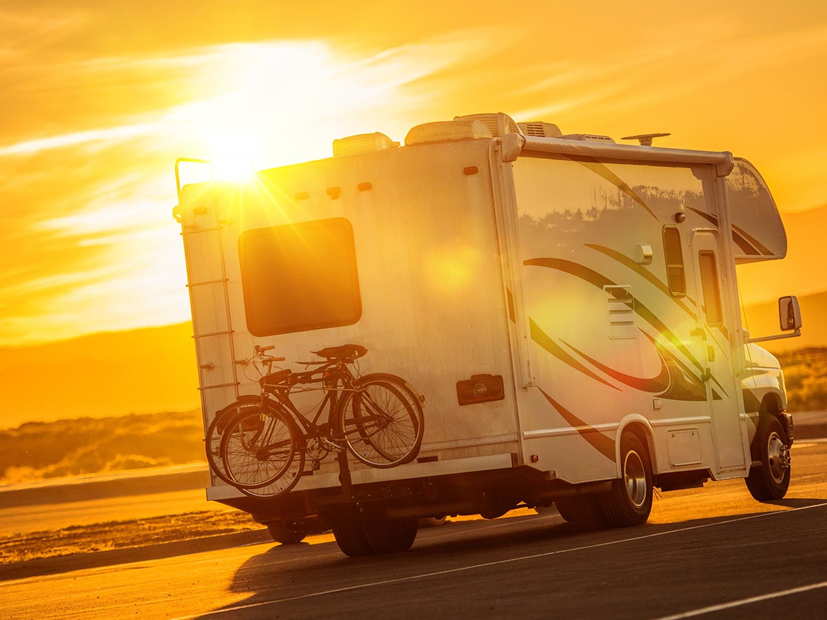 Ceramic coated RV driving on the highway as the sun is setting